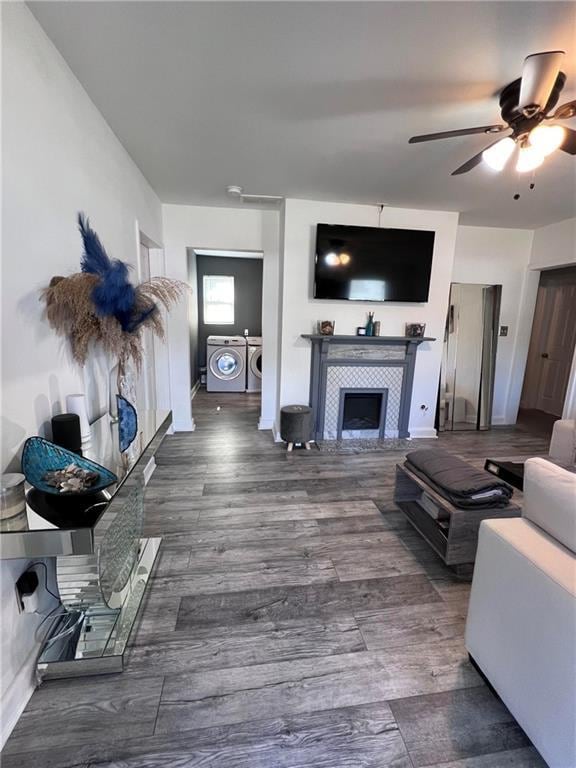 living room with ceiling fan, dark hardwood / wood-style floors, a fireplace, and washer and clothes dryer