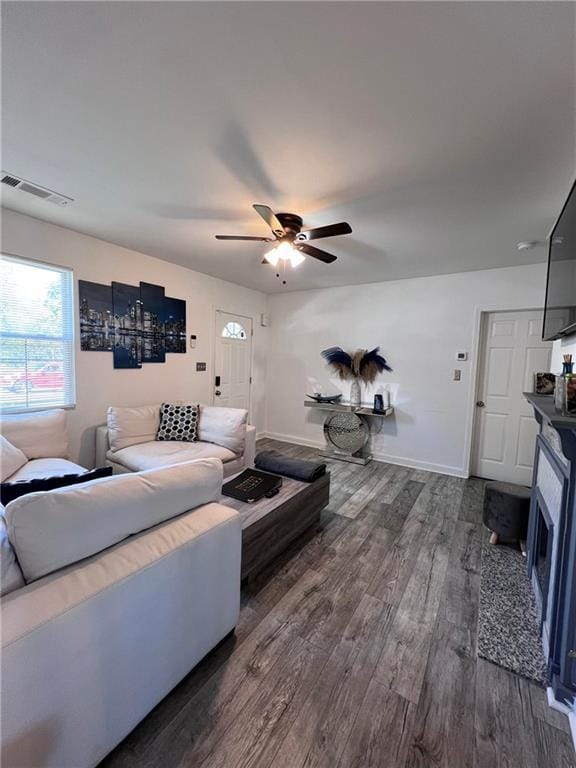 living room with ceiling fan and dark wood-type flooring