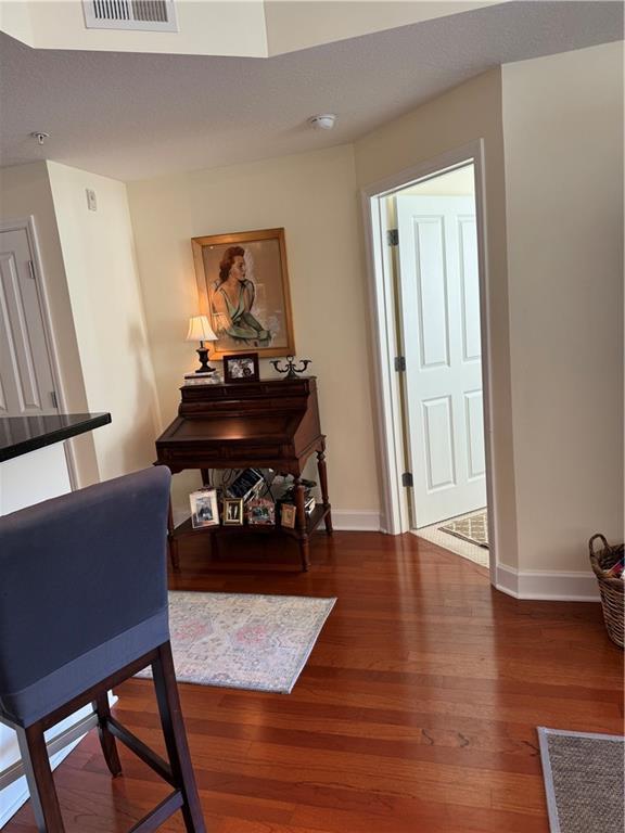 living room with a textured ceiling, dark wood-type flooring, and rail lighting