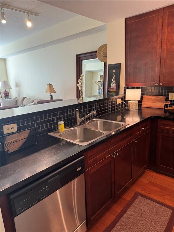 kitchen with stainless steel appliances, hardwood / wood-style floors, sink, and tasteful backsplash