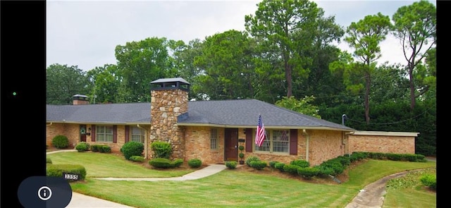 ranch-style house with a front yard, brick siding, and a chimney
