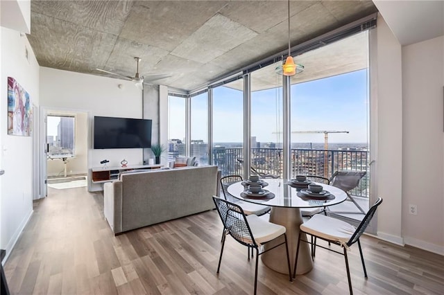 dining room featuring hardwood / wood-style floors, floor to ceiling windows, and ceiling fan