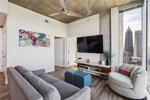 living room featuring dark wood-type flooring and ceiling fan