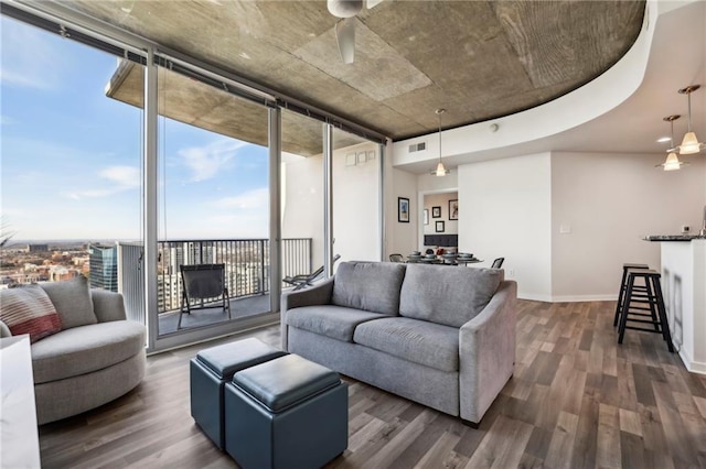 living room featuring dark wood-type flooring, ceiling fan, and expansive windows