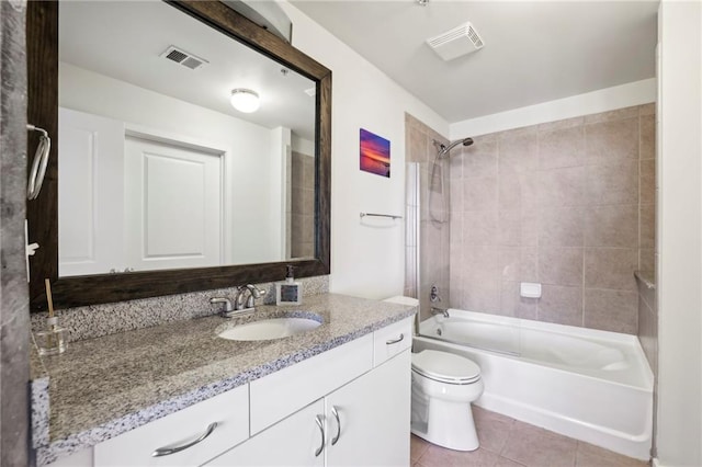 full bathroom featuring tiled shower / bath, tile patterned floors, toilet, and vanity