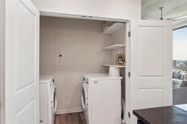 washroom with dark wood-type flooring, electric panel, and independent washer and dryer