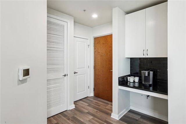 kitchen featuring hardwood / wood-style flooring, tasteful backsplash, and white cabinets