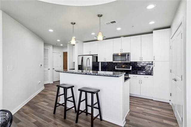 kitchen featuring appliances with stainless steel finishes, a kitchen island with sink, and white cabinets