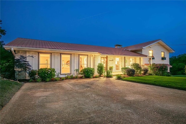 split level home with metal roof and a lawn