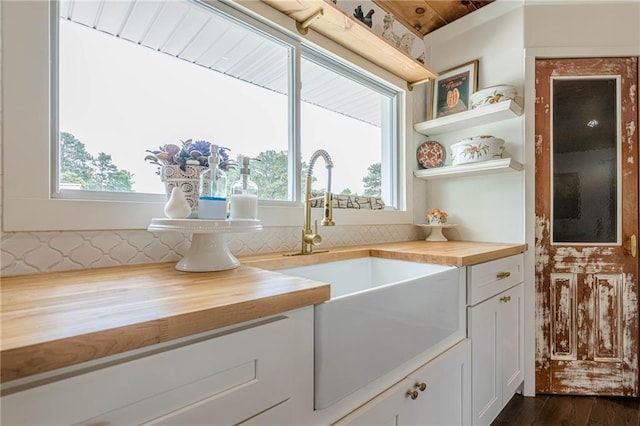 kitchen with wood counters, plenty of natural light, and a sink