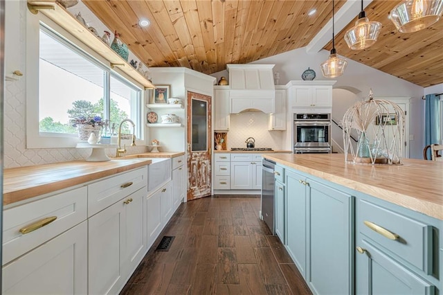 kitchen featuring wooden counters, wooden ceiling, a sink, dark wood-style floors, and decorative backsplash