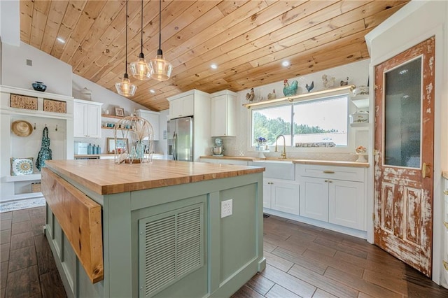 kitchen featuring butcher block countertops, stainless steel refrigerator with ice dispenser, open shelves, wood ceiling, and a sink