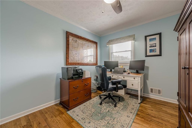 office space featuring crown molding, a textured ceiling, light wood finished floors, a ceiling fan, and baseboards