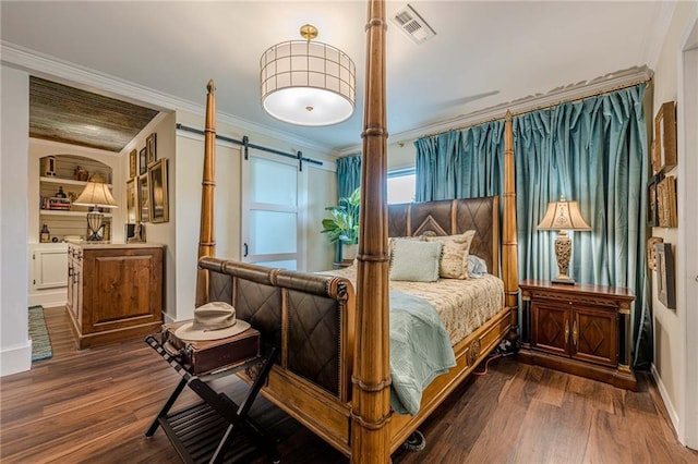 bedroom with a barn door, dark wood-style floors, crown molding, and baseboards