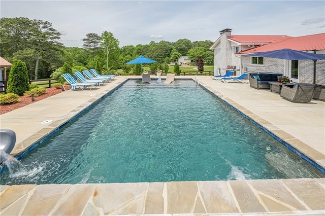 outdoor pool with a patio area and an outdoor hangout area