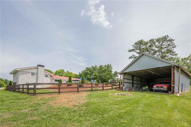 view of yard with a detached carport and an outbuilding