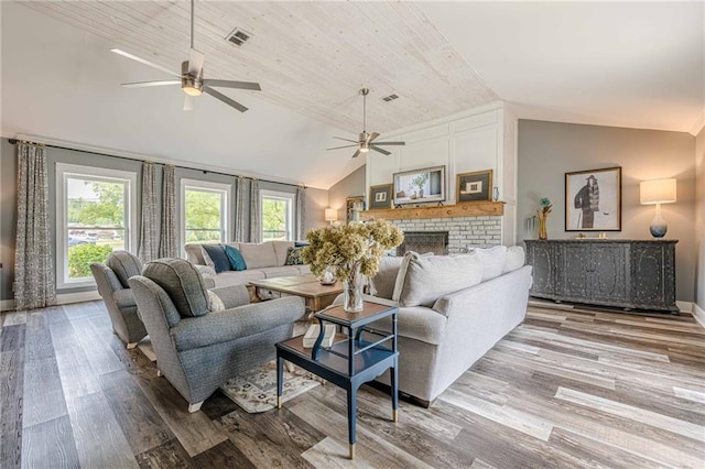 living area with lofted ceiling, ceiling fan, wood finished floors, a fireplace, and baseboards
