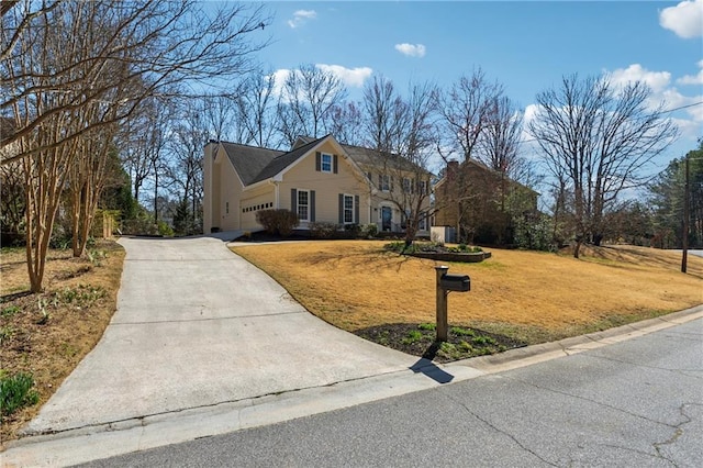 view of front of property featuring a garage, concrete driveway, and a front yard