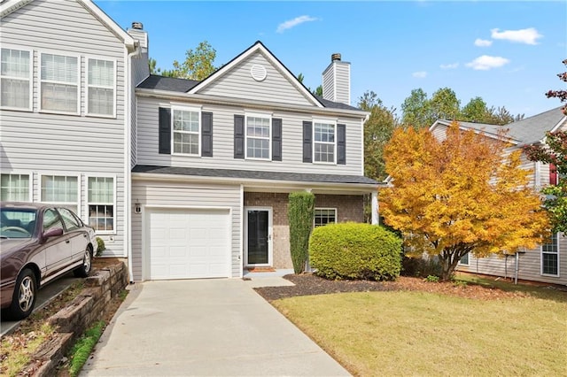 view of property featuring a front yard and a garage