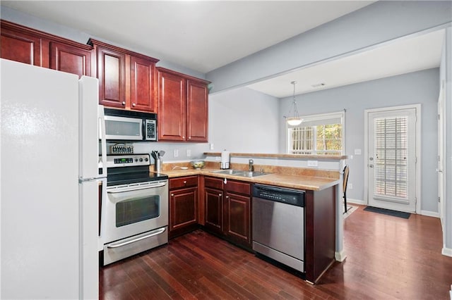 kitchen with kitchen peninsula, dark hardwood / wood-style floors, stainless steel appliances, and sink