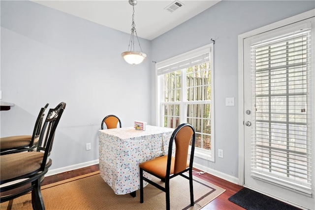 dining space with a wealth of natural light and dark hardwood / wood-style flooring