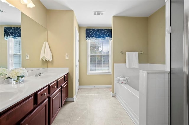 bathroom featuring vanity, tile patterned floors, and a bathtub