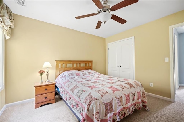 bedroom featuring light colored carpet, a closet, and ceiling fan