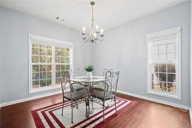 dining space with a notable chandelier and dark wood-type flooring