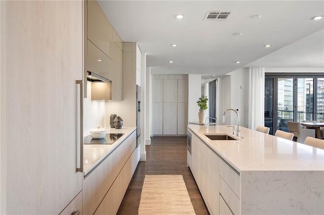 kitchen with black electric stovetop, a spacious island, sink, hardwood / wood-style flooring, and extractor fan