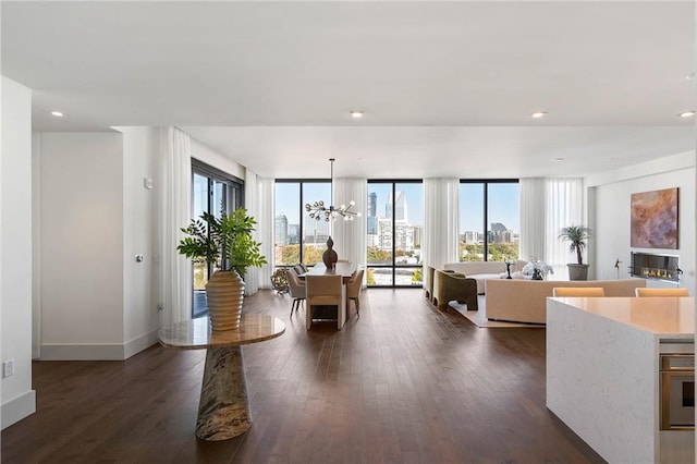 living room featuring dark hardwood / wood-style flooring, an inviting chandelier, and a wealth of natural light