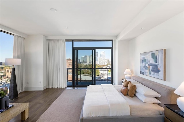 bedroom with dark hardwood / wood-style floors, a wall of windows, access to outside, and multiple windows