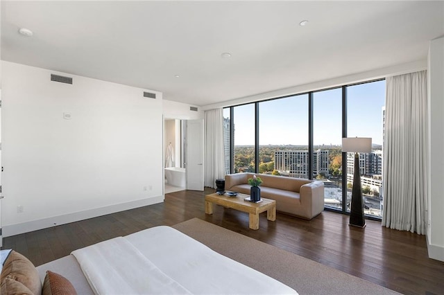 bedroom with access to exterior, connected bathroom, dark hardwood / wood-style floors, and expansive windows