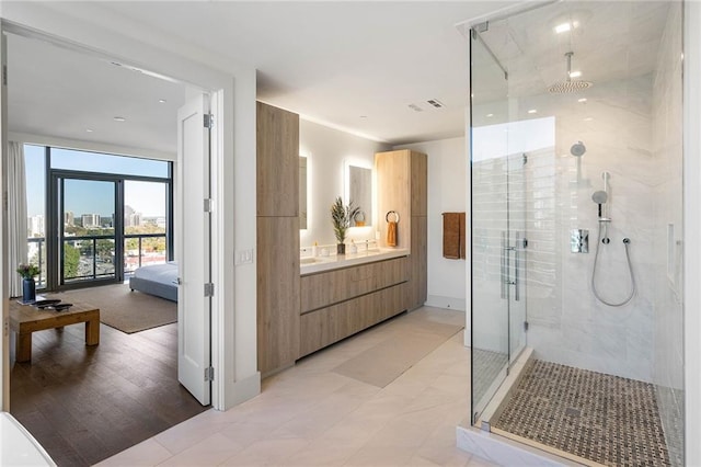 bathroom with wood-type flooring, vanity, and an enclosed shower