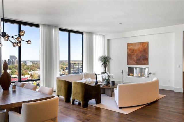 living room featuring floor to ceiling windows, dark hardwood / wood-style flooring, and an inviting chandelier