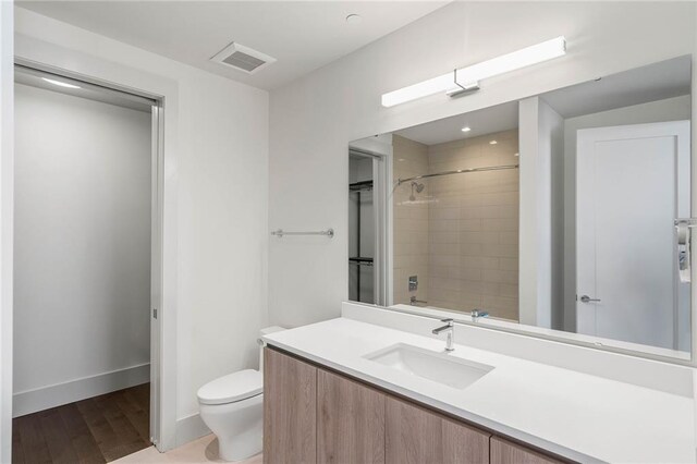 full bathroom featuring vanity, tiled shower / bath combo, hardwood / wood-style flooring, and toilet