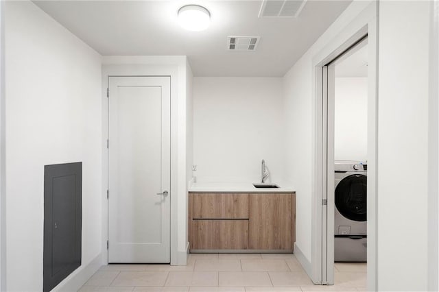 laundry room with washer / clothes dryer, sink, and light tile patterned flooring