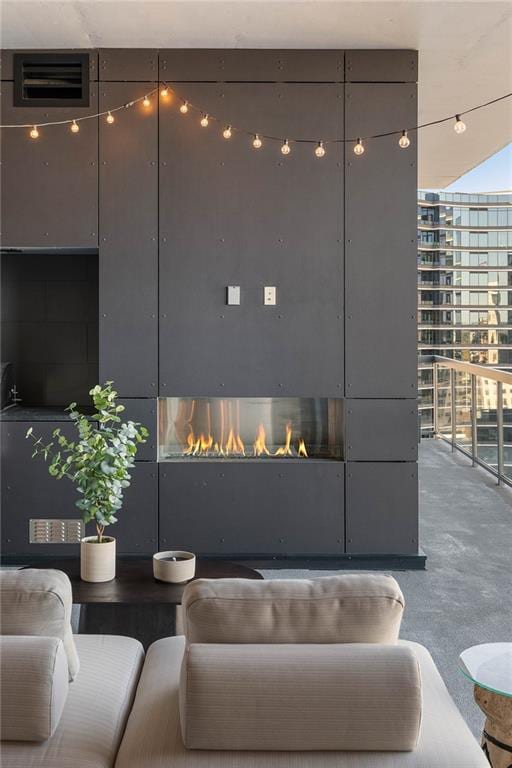 exterior space with a fireplace, concrete flooring, and floor to ceiling windows