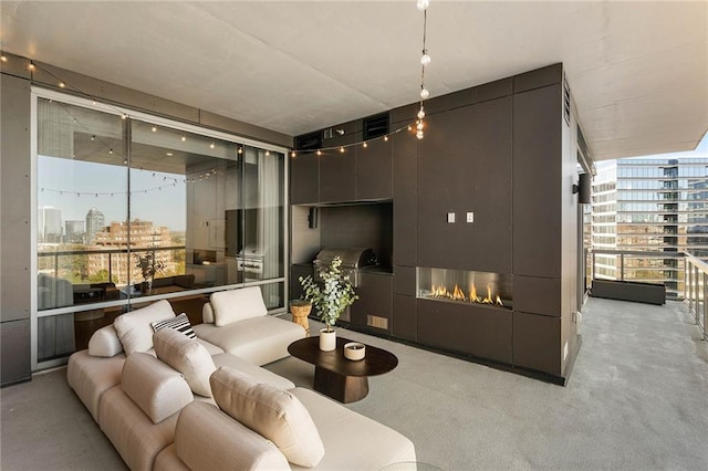 living room with a fireplace and a wall of windows