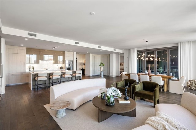 living room with dark wood-type flooring and an inviting chandelier