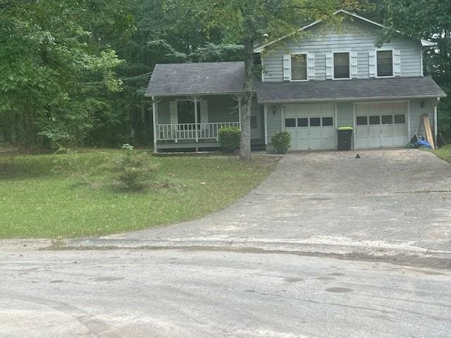 view of front of house featuring a front yard, a garage, and a porch