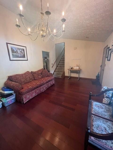 living room with a textured ceiling, hardwood / wood-style floors, and a notable chandelier