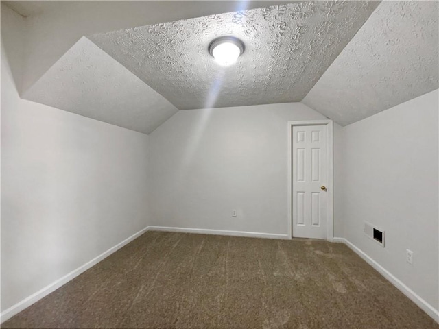 bonus room featuring baseboards, visible vents, carpet floors, vaulted ceiling, and a textured ceiling