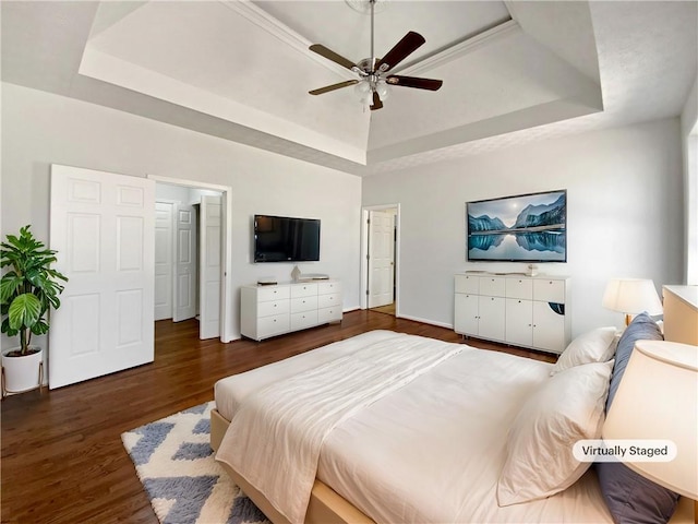 bedroom with a raised ceiling, a ceiling fan, and wood finished floors