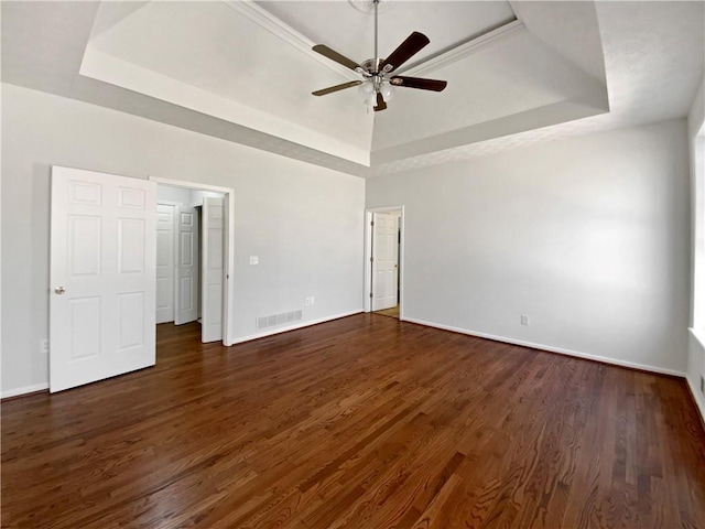 unfurnished bedroom featuring baseboards, a raised ceiling, and dark wood-style floors