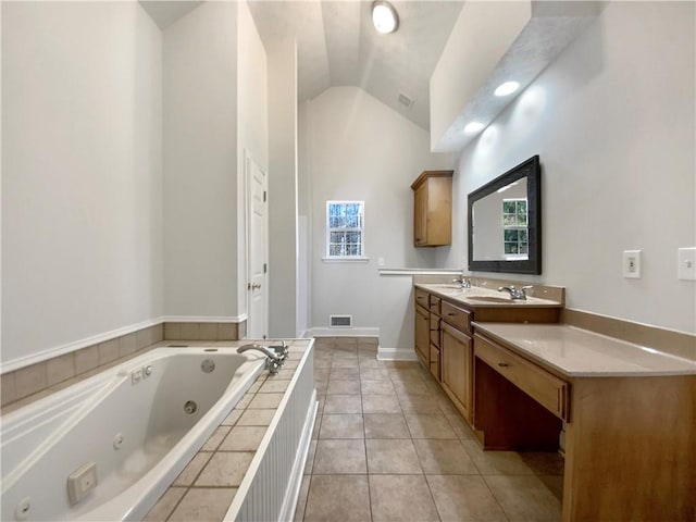 bathroom with a tub with jets, visible vents, a sink, vaulted ceiling, and tile patterned floors