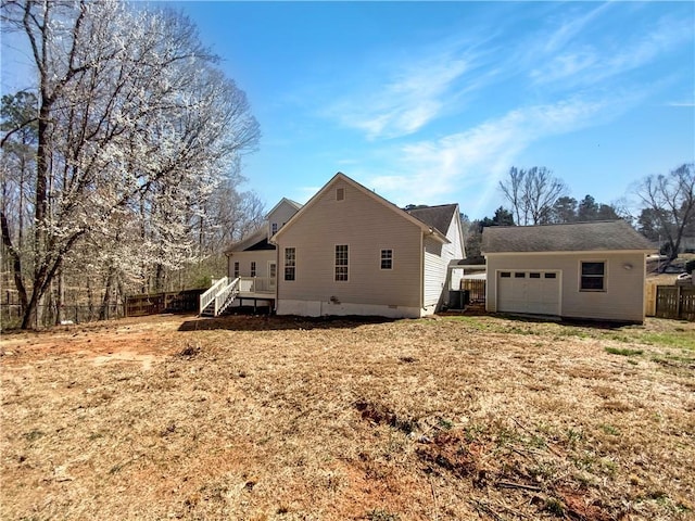 rear view of house featuring an outbuilding, fence, and crawl space