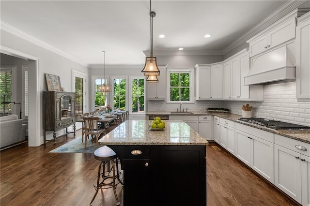 5330 Lake Redwine Cv NW, Acworth, GA 30101 - kitchen with stainless steel gas cooktop, a sink, custom range hood, a breakfast bar, and a center island