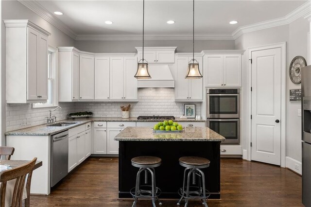 5330 Lake Redwine Cv NW, Acworth, GA 30101 - kitchen with a sink, appliances with stainless steel finishes, a center island, white cabinets, and ornamental molding