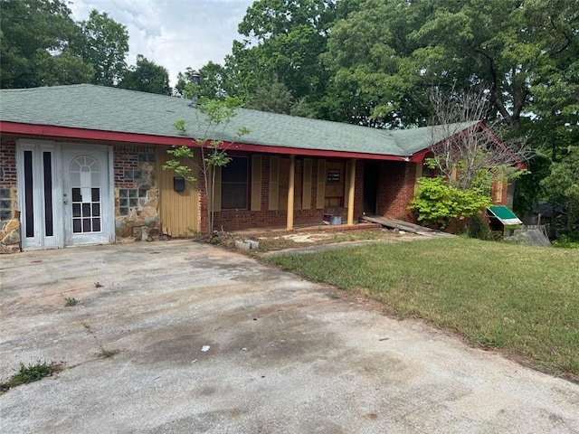 view of front of house featuring a porch, brick siding, and a front yard