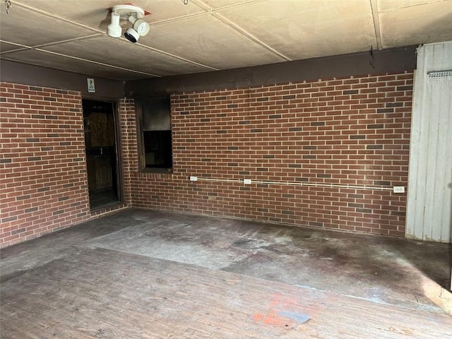 finished below grade area featuring brick wall